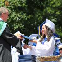 <p>A graduate receives her diploma.</p>