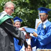 <p>A graduate smiles and is happy to receive his diploma. </p>