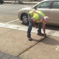 <p>A city workers does some last-minute weeding before the ceremony Friday morning at Kennedy Park in Danbury. </p>