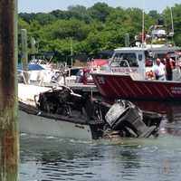 <p>Firefighters survey the area at the South Benson Marina complex damaged by the Sunday blaze.</p>