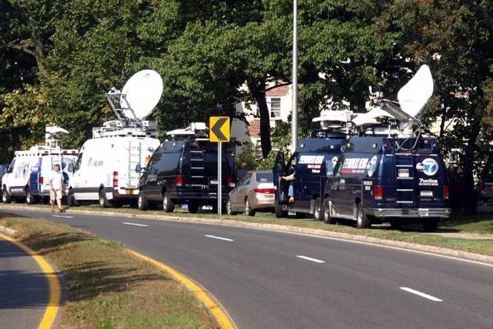 Satellite trucks line Washington Boulevard in Stamford on Oct. 4 as officials investigate the shooting death of a Stamford woman by Capitol Police. Investigators were searching her home for evidence in the case. 