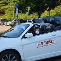 <p>The driver of an old timers vehicle gives a thumbs up.</p>