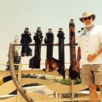 <p>Larry Kleinman in front of a Hanukkah menorah made from Kassam rockets in Sderot.</p>