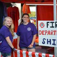 <p>Erin Fredericks (left) and Isabelle Avanzato (right) stand at the t-shirts booth for the Patterson Fire Department&#x27;s carnival.</p>