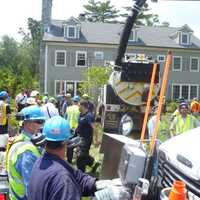 <p>Emergency workers use a City of Rye Vac-truck to clear a collapsed trench that trapped two men. </p>