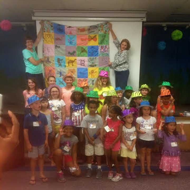 Vacation Bible School participants proudly display their quilt.