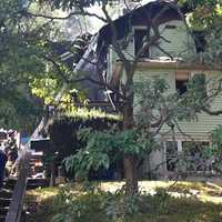 <p>Norwalk firefighters put out the last smoldering remains of the house fire on Riverside Avenue on Thursday.</p>