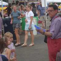 <p>Kids take a break from music and barbecue to get some balloon animals.</p>