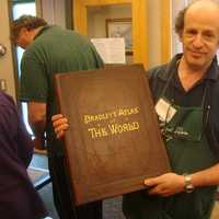 <p>Paul Weissman displays an 1889 atlas on sale at the Mark Twain Library&#x27;s annual book fair at the Redding Community Center.</p>