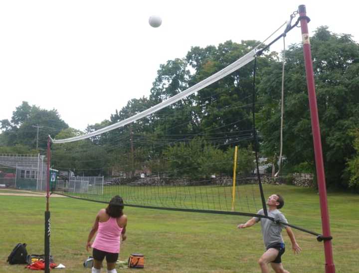 A group of friends gathers together for a game of volleyball in Barrett Park in Stamford on Monday on the unofficial end of summer.