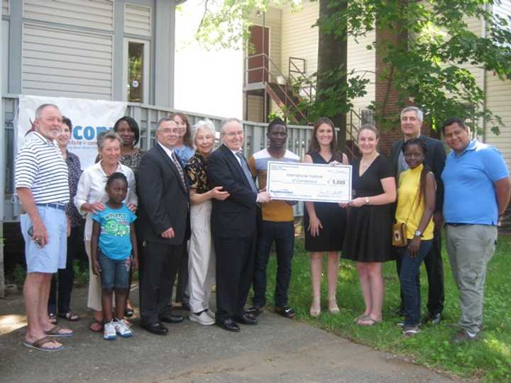 Armando F. Goncalves, Officer of People&#x27;s United Community Foundation and Southern Connecticut President at Peoples United Bank, presents a check to Angela R. Andersen, IICONN Executive Director, while mentors and mentees look on.