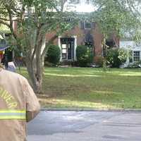 <p>A Turn of River Volunteer Fire Department firefighter looks at the front of 25 Bittersweet Lane in North Stamford. It was totally destroyed by an early-morning fire Wednesday.</p>