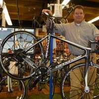 <p>Mike Conlin stands behind a cutting-edge bike at Outdoor Sports Center.</p>