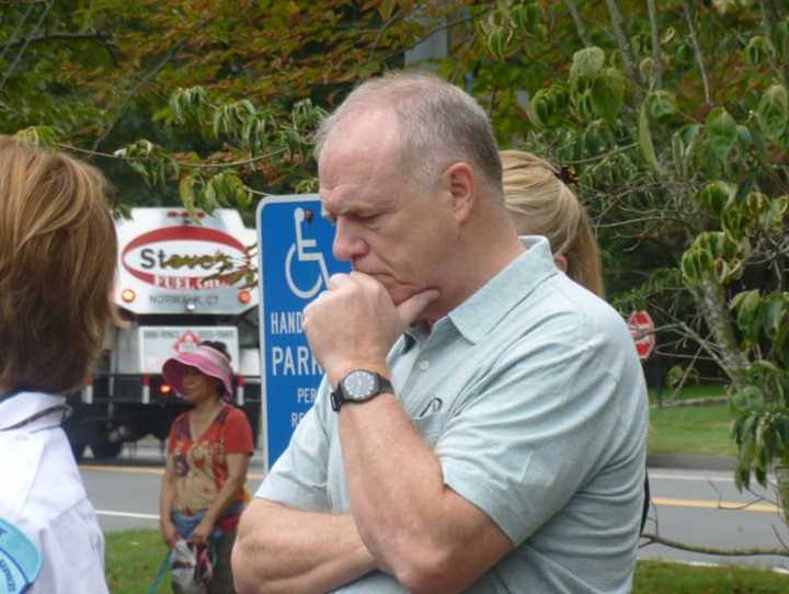 An attendee at the New Canaan 9/11 ceremony pauses to remember. About 80 people gathered in front of police headquarters for the event that began at 9:59 a.m., the same time the first tower collapsed at the World Trade Center on Sept. 11, 2001.