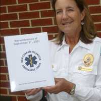 <p>Wendy Humboldt, captain of the New Canaan Volunteer Ambulance Corps, holds a book of 9/11 memories compiled by corps members.</p>