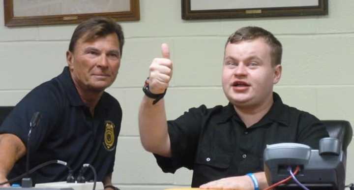 Patrick Kogut gives a thumbs up after he was handed an envelope with money and gift cards donated by police and citizens angered at the theft of $100 from the autistic man last week. Police arrested a Stamford man in the theft.