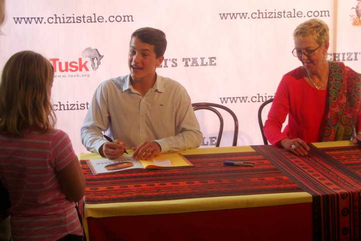 Greenwich teen Jack Jones and Zimbabwe illustrator Jacqui Taylor sign copies of &quot;Chizi&#x27;s Tale&quot; for young fans.