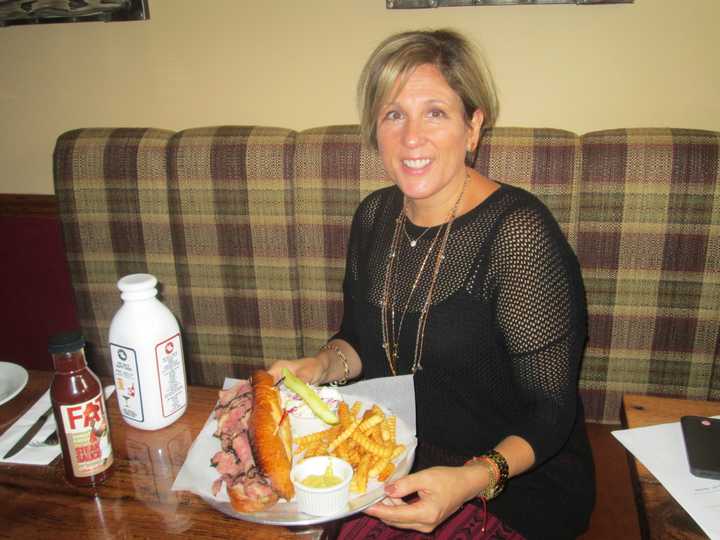 Audrey Hochroth in front of a pastrami sandwich, one of the delicacies offered at Fat Sal&#x27;s.