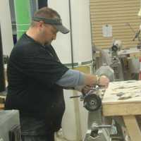 <p>Jay Mather of Tucci Lumber Co. sands a baseball bat.</p>