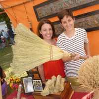 <p>Anne Hopkinson, left, and Janelle Higdon, of Haydenville Broomworks, display an old-fashioned broom that they make and sell. They are located in Haydenville, Mass., and were at the Ambler Farm fall festival on Sunday.</p>