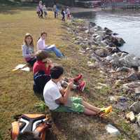 <p>Students take a break by the river. </p>