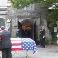 <p>The American flag-draped casket of former Congressman Peter A. Peyser outside of the Church of St. Barnabas before his burial at Sleepy Hollow Cemetery on Monday.</p>