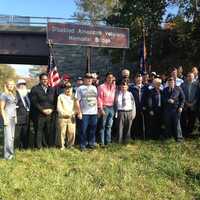 <p>Ball, Galef and veterans take a photo under the bridge. </p>