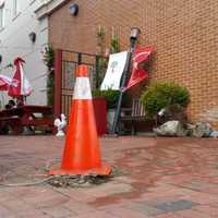 <p>An orange cone sits about 15 feet from the brick wall where the BMW X3 that struck Chief of Police Gary MacNamara&#x27;s unmarked police vehicle, made contact with a light post on the Firehouse Deli patio.</p>