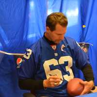 <p>Karl Nelson autographs a football as part of his appearance at the Stop &amp; Shop in Baldwin Place.</p>