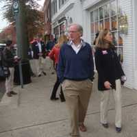 <p>Foley and Stevenson, followed by a crowd of supporters, take a stroll down Post Road in downtown Darien Friday.</p>