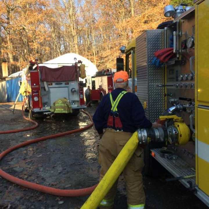Members of the Weston Volunteer Fire Department help battle a brush fire on Highland Avenue. 