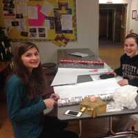 <p>Members of the Village Lutheran Church Youth Group wrap presents that will be given to children in need.</p>