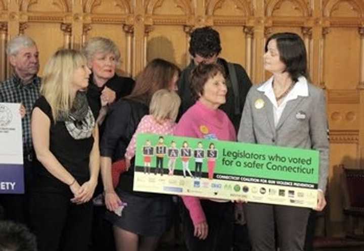 Members of Connecticut Against Gun Violence celebrate the one-year anniversary of the passage of Connecticut&#x27;s stricter gun laws earlier this year. 