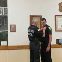 <p>Elmsford Police Commissioner Frank Rescigno pinned his 30-year-old badge on his son, Paul, the village&#x27;s newest patrol officer.</p>