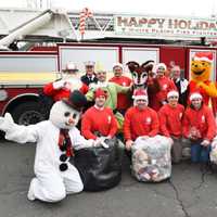 <p>Frosty the Snowman, Winnie the Pooh and other Santa&#x27;s helpers after arriving aboard a White Plains fire engine.</p>