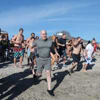 <p>Those taking the plunge get a running start on Compo Beach. </p>