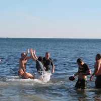 <p>A few participants, including Batman, savor the cold water of Long Island Sound. </p>