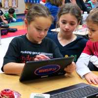 <p>Todd Elementary School fourth-grade students and first-graders play a Cool Math game on a personal device.</p>