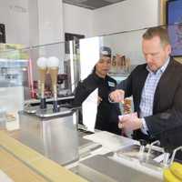 <p>Lead designer Tom Kowalski shows the proper technique to dipping an ice cream bar in Bronxville.</p>