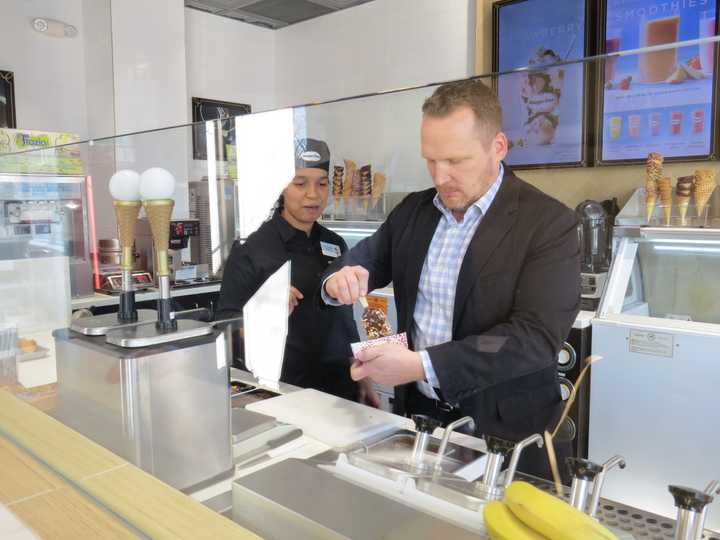 Lead designer Tom Kowalski shows the proper technique to dipping an ice cream bar in Bronxville.