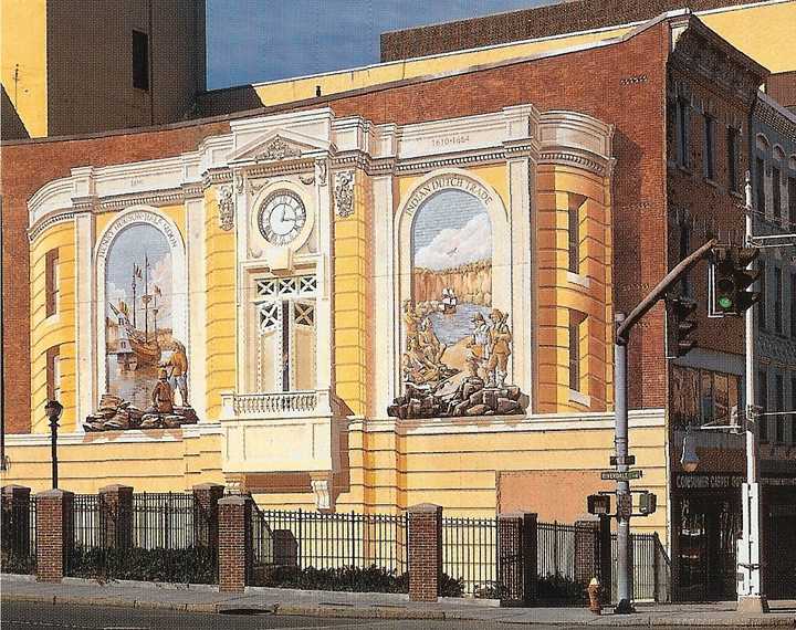 The Carpet Outlet Building: 36 Main St. (The Dutch Mural) with the unfinished parklet next to it.