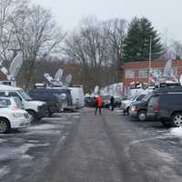 <p>Satellite trucks from TV stations fill the parking lot. </p>