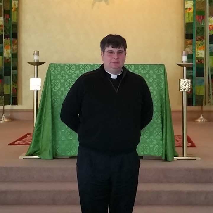 The Rev. Bret Stockdale, S.J., stands in front of the alter at Egan Chapel on Fairfield University&#x27;s Campus.