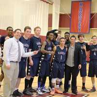 <p>Ricky Hicks&#x27; teammates and coaches, Mike Rubenfeld (left) and Dom Narcisco (right), pose for celebratory photo after the senior point guard collects his 1000th career point for Harvey.</p>