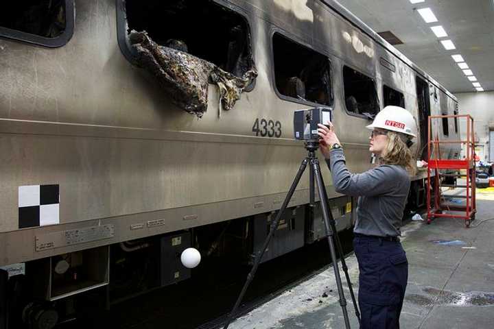 National Transportation Safety Board investigator Kristin Poland sets up 3D Laser Scanner to create model of the damaged rail car. 