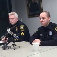 <p>Officer Neil Robertson (right) with Sgt. Terry Blake discuss how Robertson managed to prevent a train from hitting a car in Norwalk.</p>