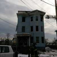 <p>Bridgeport firefighters douse the blaze at a three-story multifamily home on Wednesday afternoon.</p>