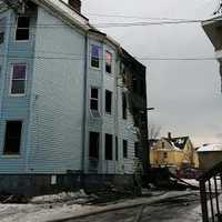 <p>Bridgeport firefighters douse the blaze at a three-story multifamily home on Wednesday afternoon.</p>