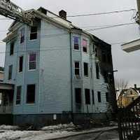 <p>Bridgeport firefighters douse the blaze at a three-story multifamily home on Wednesday afternoon.</p>