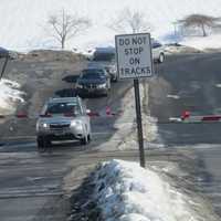 <p>Cars wait at the Roaring Brook railroad crossing.</p>